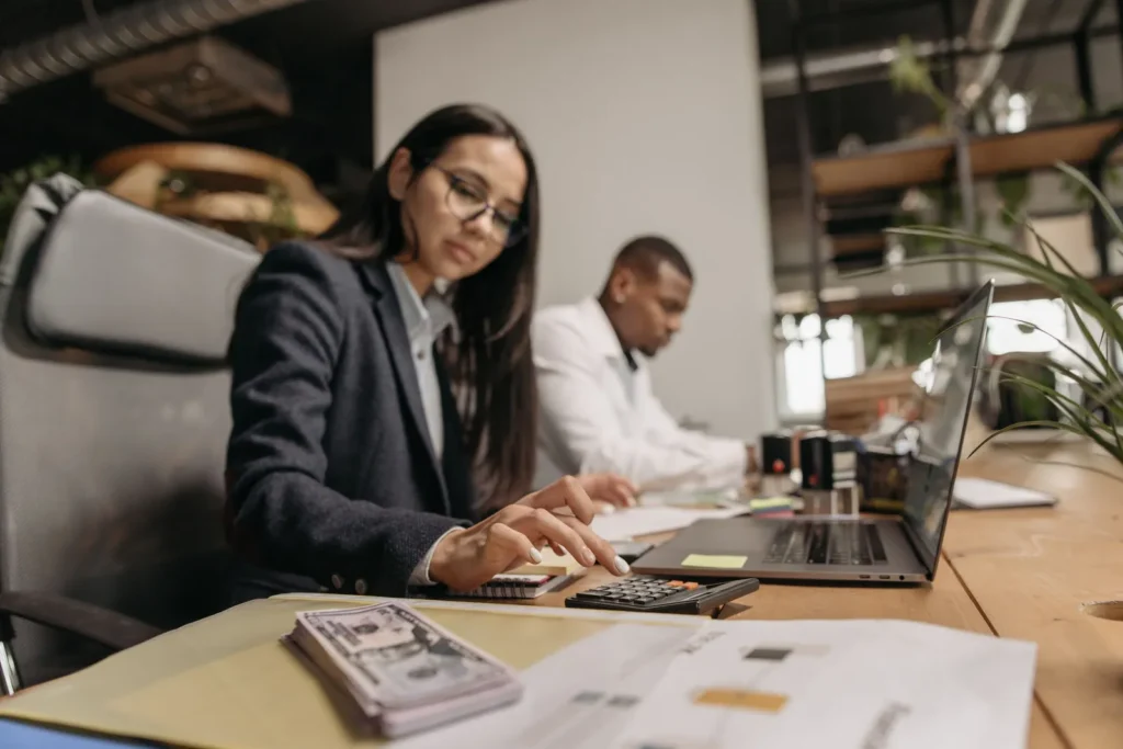 Accountants working with a calculator and laptop