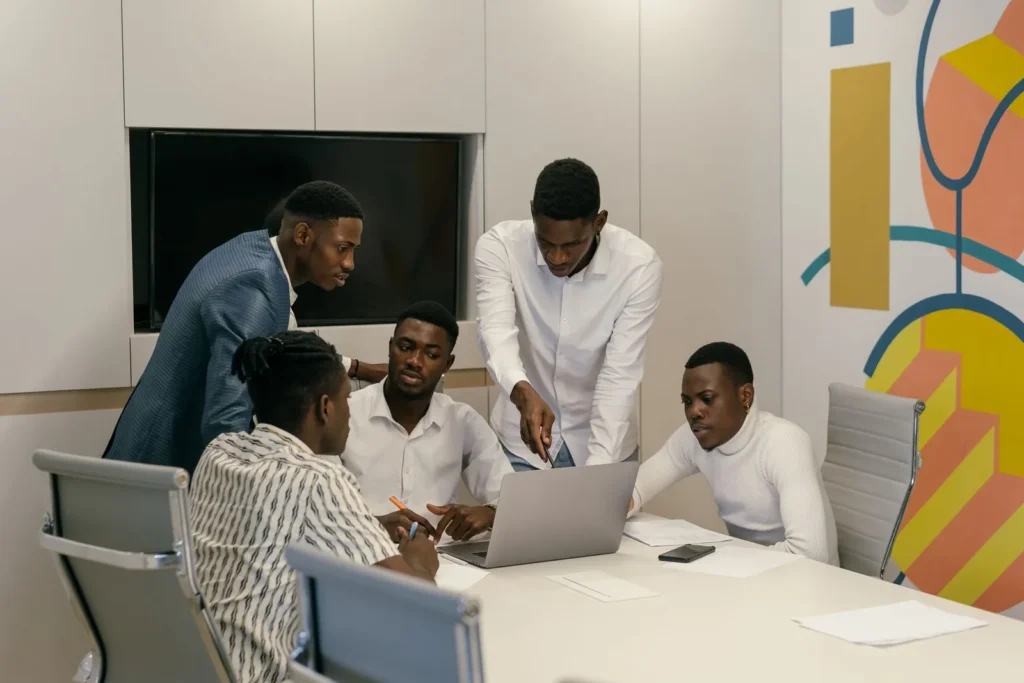 Team gathered around a laptop in a modern meeting room