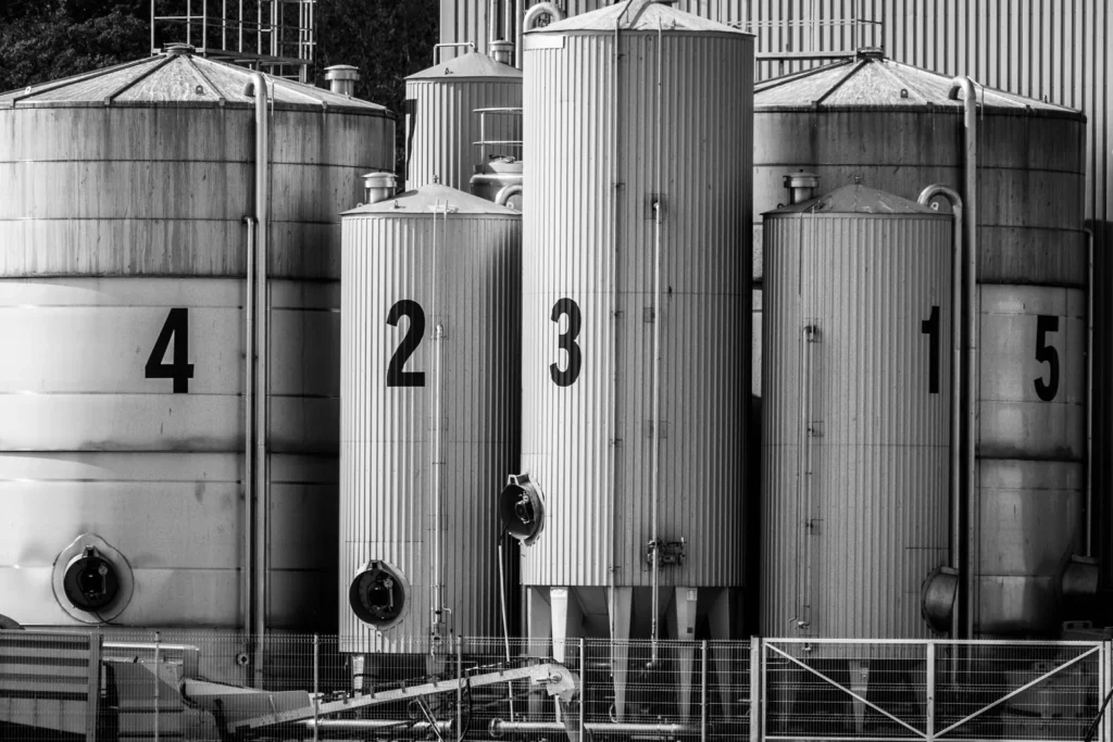 Rows of numbered industrial storage silos in black and white