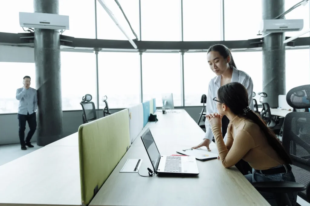 Colleagues working at long desks in a glass-walled office