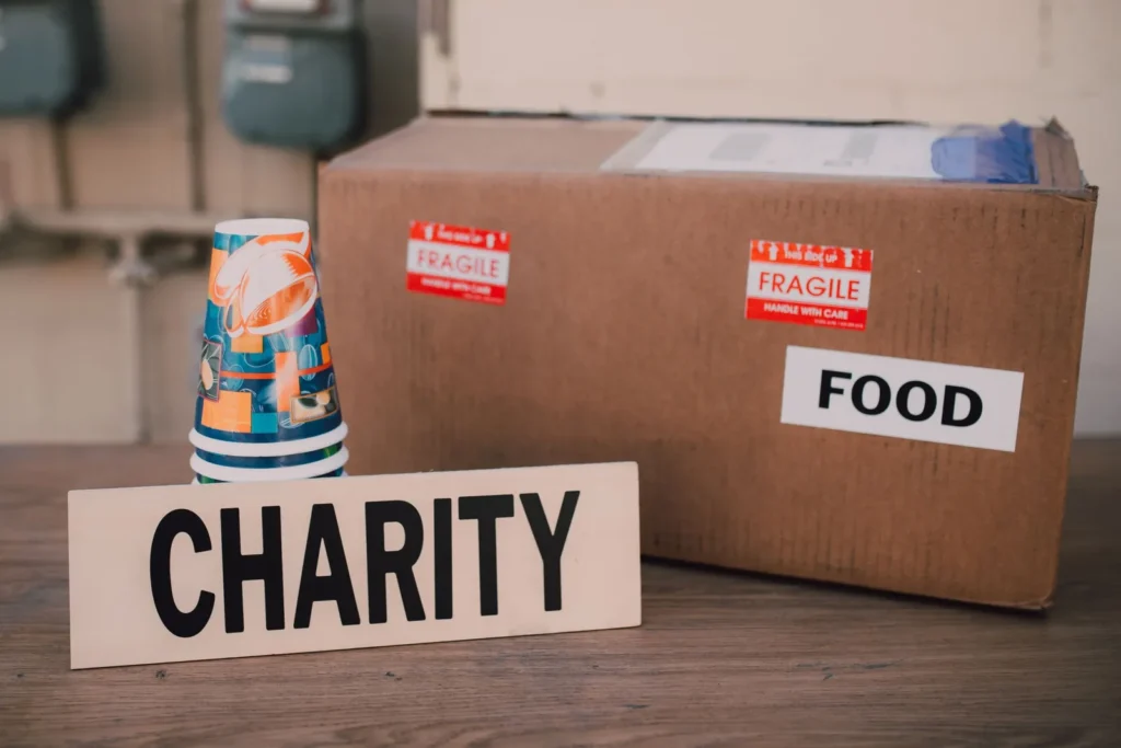 Charity sign beside a cardboard box of food donations