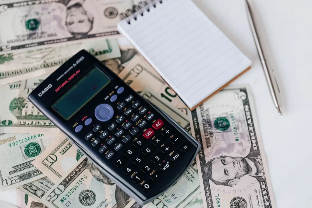 Calculator, notepad and banknotes on a desk