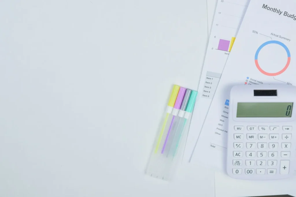 Monthly budget documents, charts and a calculator on a desk